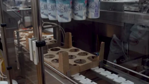 The sour cream is put in the boxes automatically. The robot packs in the factory Stock Footage 136076639
