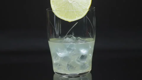 Sour Drops Are Dripping From Slice Into Glass With Juice Cocktail Full Of Ice Stock Footage 116564221