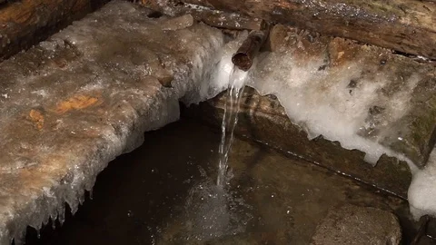 The source of artesian water flows in the winter Christmas. Fun water rushing. Stock Footage 99632233