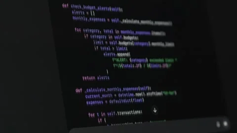 Source code displayed on monitor during vibe coding with ai assistant on dark Video stock 330167921