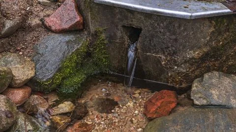 Source of drinking water in the forest. Strange Fountain With Drinking Water. Stock Photos