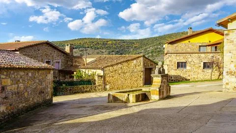 Source of fresh mountain water in the square of the old stone village, Spain. Stock Photos