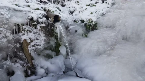 Source of fresh water with an abundant stream. Everything around is frozen and Stock Footage 149487763