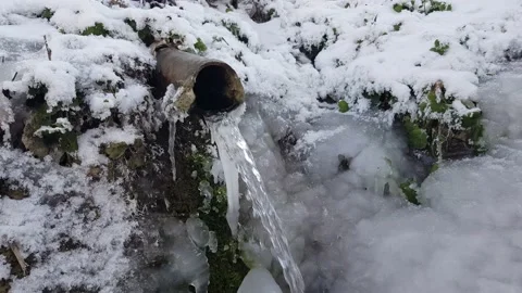 Source of fresh water with an abundant stream. Everything around is frozen and Stock Footage 150815373
