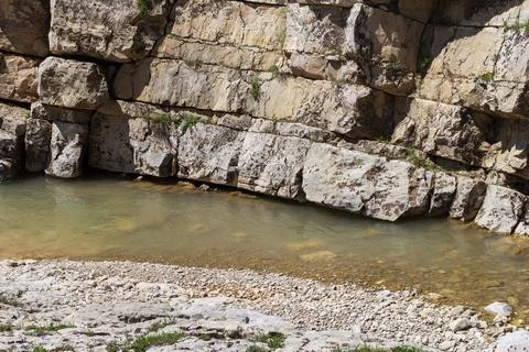 The source of the mountain river originates in the mountains on alpine meadow Stock Photos