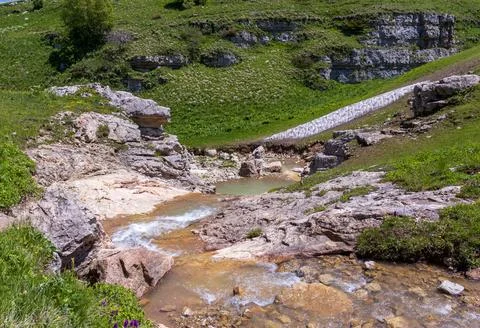 The source of a mountain river, on the slopes and in a stone riverbed in the Stock Photos