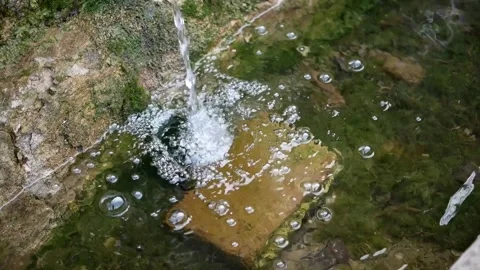 The source of pure mountain water.  water flows into a stone basin Stock Footage 265172251
