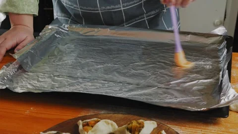 The source spreads the vegetable oil onto the baking foil. Slowmotion. Stock Footage 272259910
