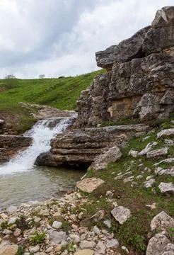 The sources of a mountain river high in the mountains on alpine meadows durin Stock Photos