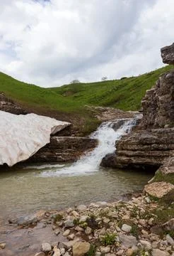 The sources of a mountain river high in the mountains on alpine meadows durin Stock Photos