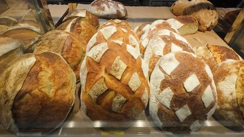 Sourdough bread in a glass display case in a supermarket. 库存影片 316521647