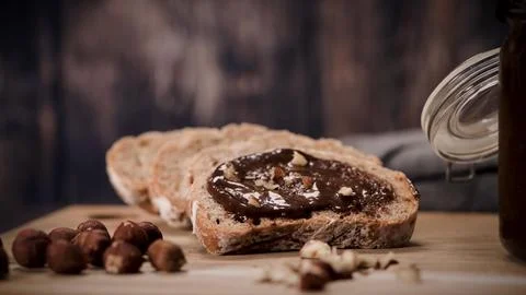 Sourdough Bread Slice with Chocolate Hazelnut Spread and Whole Nuts on Wood.. Stock Photos