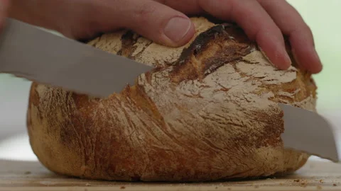 Sourdough bread is sliced with a knife Stock Footage 166338809