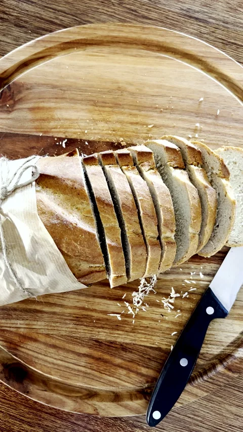 Sourdough loaf of bread cut into slices on wooden cutting board Stock Footage 344010503