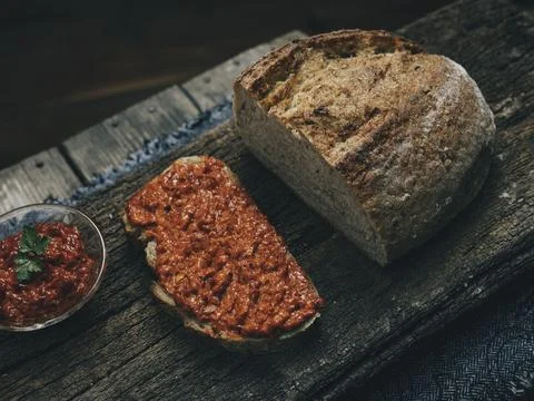 Sourdough, rye bread with ajvar spread on it. Stock Photos