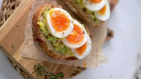 Sourdough Toast Topped with Smashed Avocado and Soft Boiled Egg Slices Stock Footage 330689829