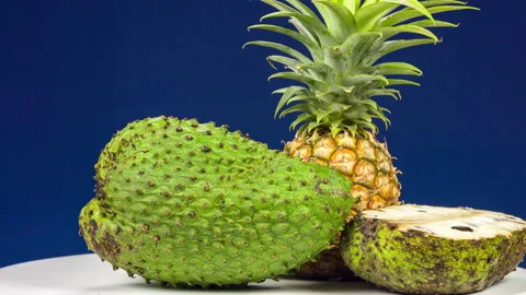 Soursop, graviola, guyabano and pineapple isolate rotation on blue background Stock-Footage 89596338