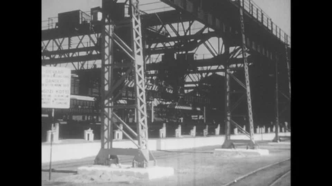 South Africa 1960s: Container cranes. Train moves in front of factory buildings Stock Footage