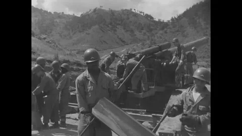 SOUTH KOREA - 1953: Breech loading - Artillerymen ram a shell into the open gun Stockbeeldmateriaal 344502520