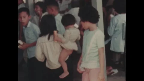 SOUTH VIETNAM - 1968: Camera operator - Servicemen record family aid gathering Stock Footage 344483901