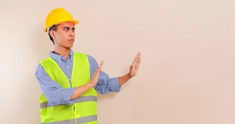 Southeast Asian construction worker in hard hat and safety vest showing rej.. Stock Photos