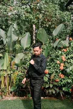 A Southeast Asian man checking the time on his wristwatch, Stock-Fotos