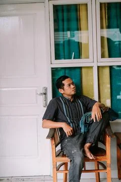 Southeast Asian Man Contemplating While Sitting by Window Stock Photos