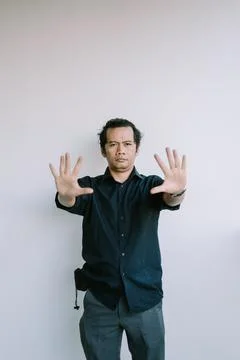 Southeast Asian man refusing an offer, gesturing with a hand raised in declin Foto stock