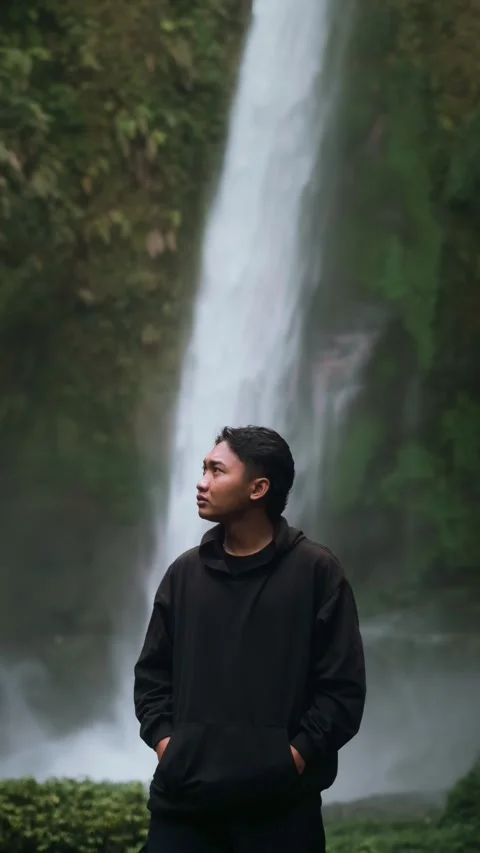 Southeast Asian Man Standing in Front of the Waterfall Stock Footage 307050185