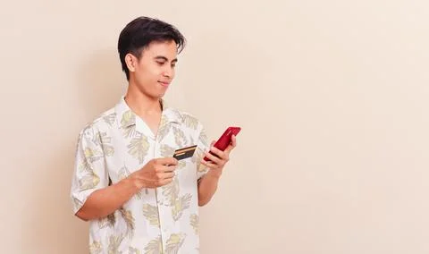 Southeast Asian man using smartphone and holding credit card for online sho.. Stock Photos
