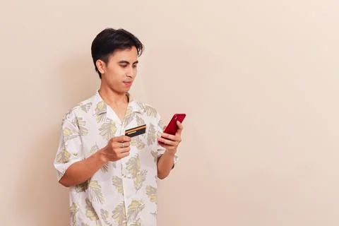 Southeast Asian man using smartphone and holding credit card for online sho.. Stock Photos