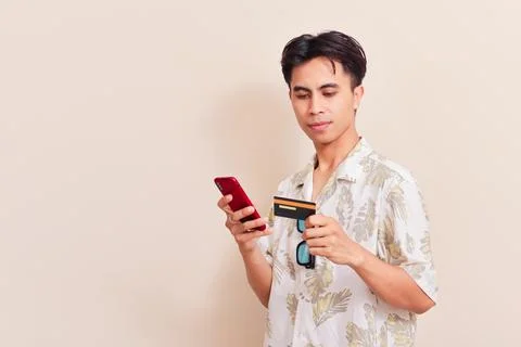 Southeast Asian man using smartphone and holding credit card for online sho.. Stock Photos
