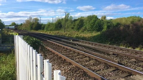 Southeastern train speeding past railway crossing on track near Canterbury, UK. Stock Footage