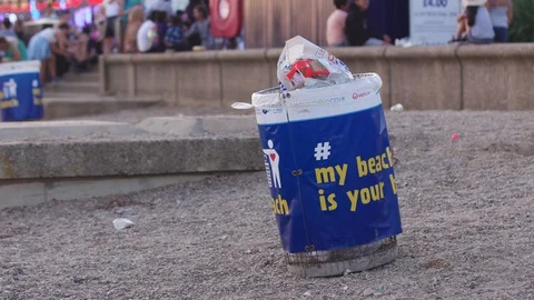 Southend, UK - Circa 2019: Full litter bin overflowing with rubbish on a sandy 스톡 동영상 129344576