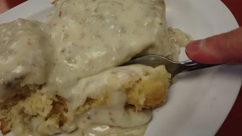 Southern biscuits and gravy fork diving into biscuit eating breakfast Stock Footage 214149064