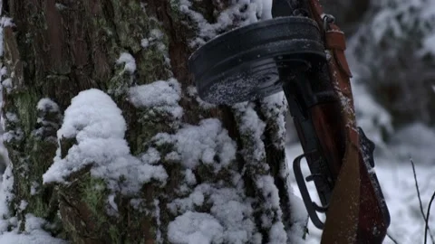 Soviet automatic PPSH stands at a tree in the winter climb Stock Footage 220712095