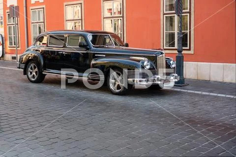 Soviet limousine ZIS-110 parking on a cobblestone street Stock Photos