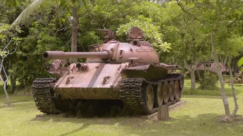 Soviet-made tank T54 is standing under the crowns of the trees in War Museum  Stock Footage 318725523