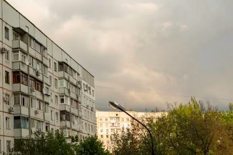Soviet panel houses before the storm. Clouds over multistory houses. Stock Photos