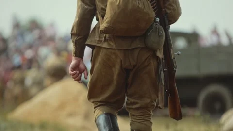 Soviet soldier of Red Army with Mosin rifle walks through field before battle Video stock 314888105