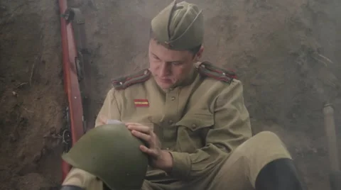 Soviet soldier sits in the trenches, and writes a letter. World War II. Stock Footage 65964323