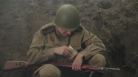 Soviet soldier sits in the trenches during the battle, gets a photo from  pocket Stock Footage 65963927