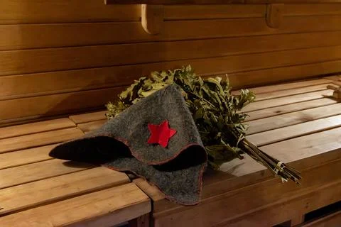 Soviet-style hat and bath broom in a rustic sauna Stock Photos