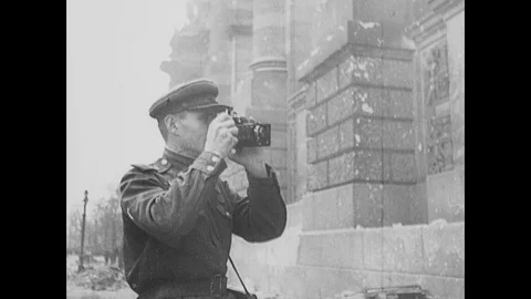 Soviet troops pose for a photograph, triumphant grafitti covers buildings Stock Footage 103382977