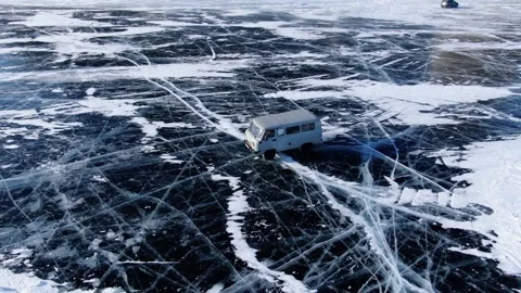Soviet white car UAZ rides on the icy surface of frozen Baikal lake. Vídeos de archivo 165493956