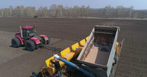 Sowing. A farmer loads grain into a seeder from a truck. Stock Footage 160546121