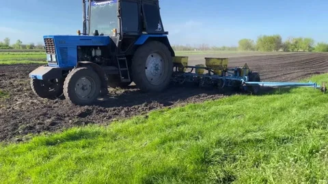 Sowing the field with corn grains. tractor works the field with a seeder. close Stock Footage 240539403