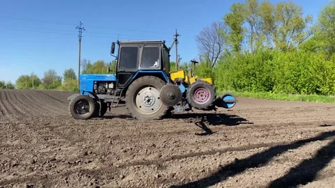 Sowing the field with corn grains. tractor works the field with a seeder. close Stock Footage 240759077