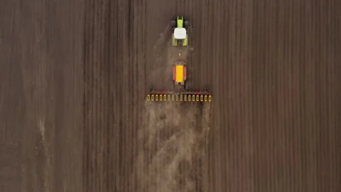 Sowing machine tractor sows seeds in an agricultural field. Aerial view Stock Footage 162185956