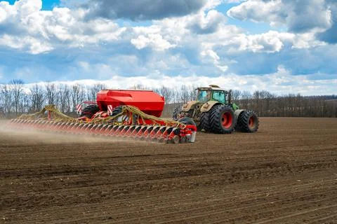Sowing work in the field in spring. Tractor with seeder Foto stock